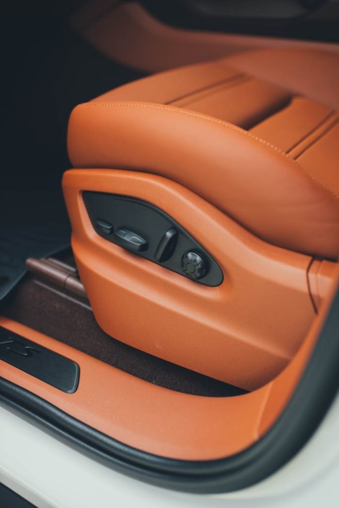 luxury-car-seating-adjustment-17339312 Detailed view of a luxurious automotive seat with elegant design.
